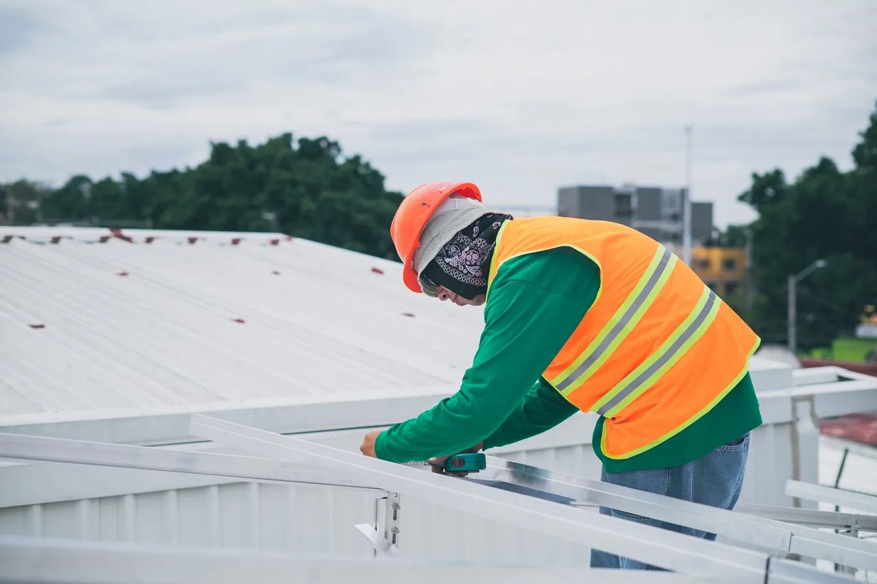 Maintenance worker repairing details on a commercial rooftop
